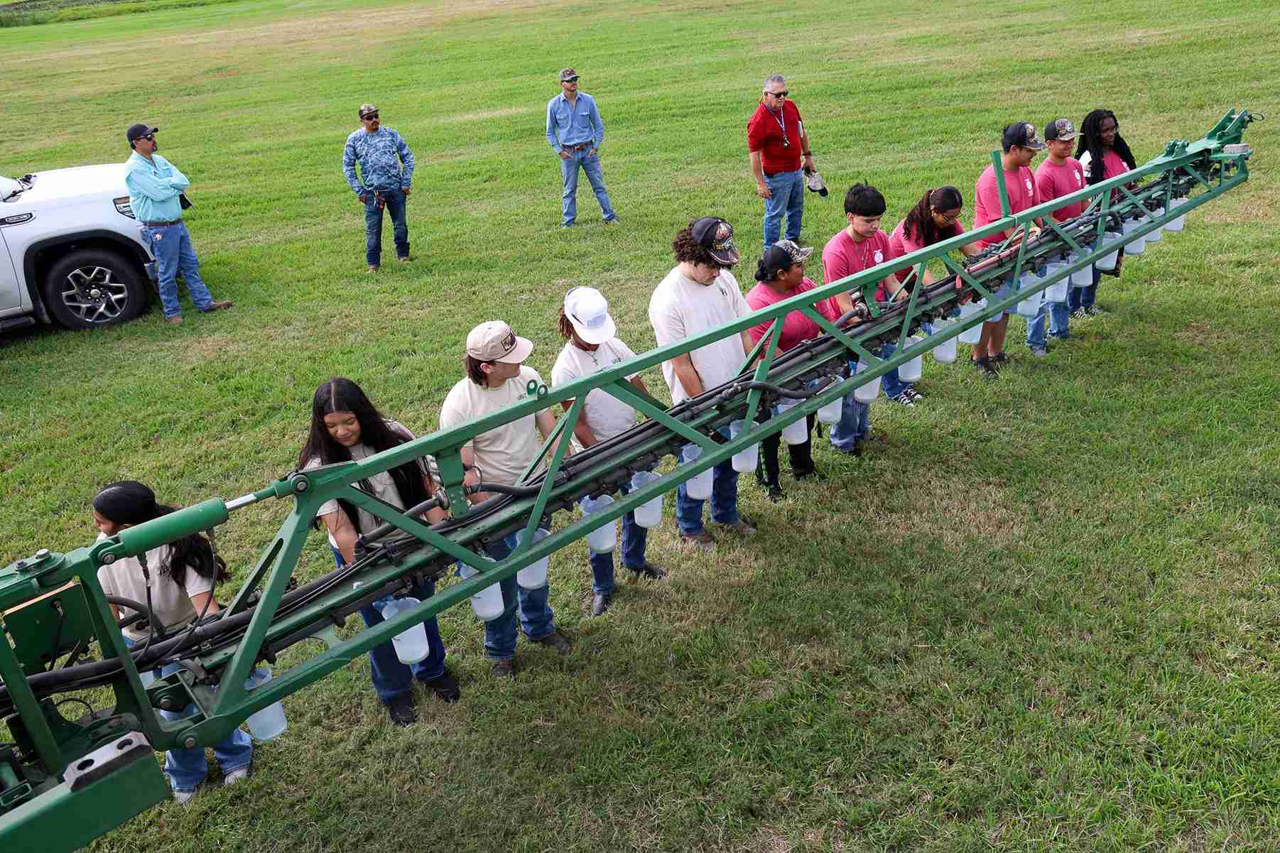 people standing at tractor boom